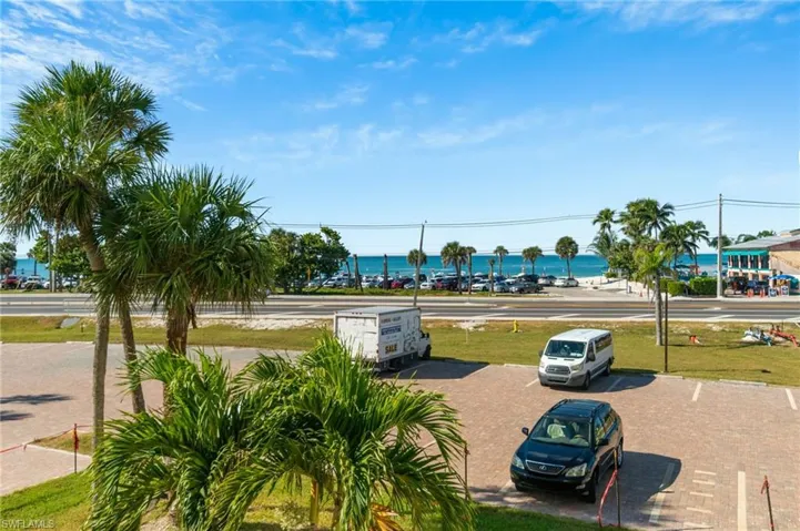 View of property's community with a water view and uncovered parking