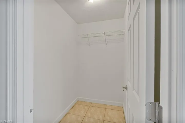 Walk in closet with light tile patterned flooring