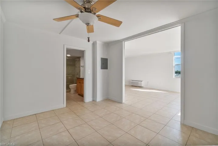 Spare room with crown molding, light tile patterned flooring, ceiling fan, and electric panel