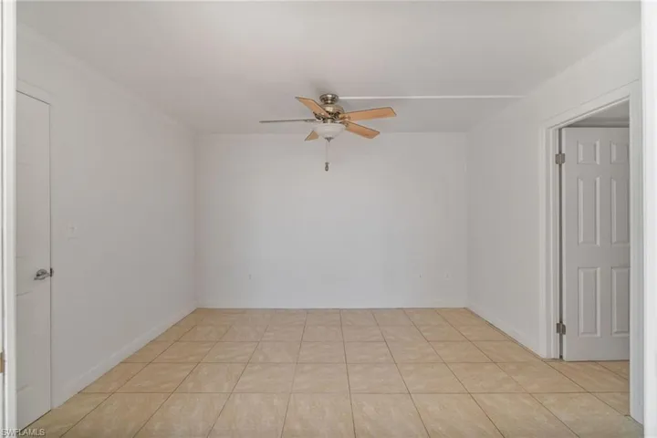 Unfurnished room with crown molding, ceiling fan, and light tile patterned floors