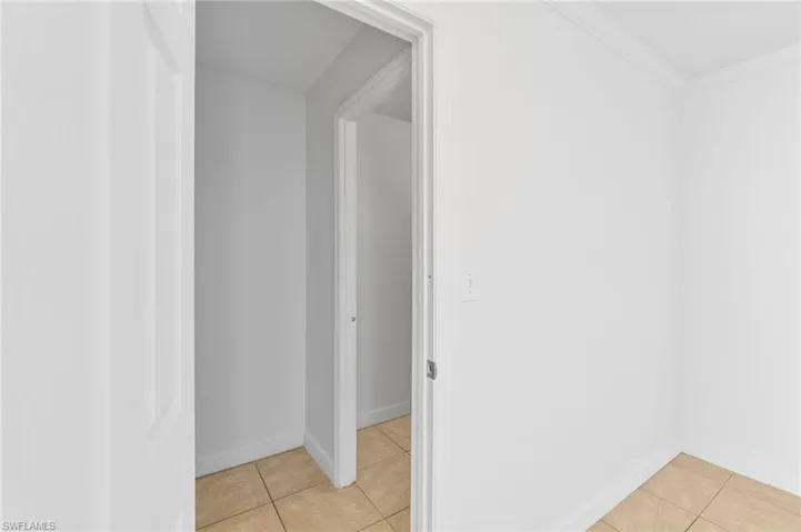 Hall featuring light tile patterned floors and ornamental molding