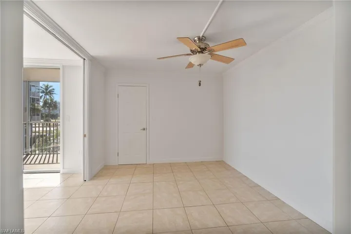 Spare room with ornamental molding, ceiling fan, and light tile patterned flooring