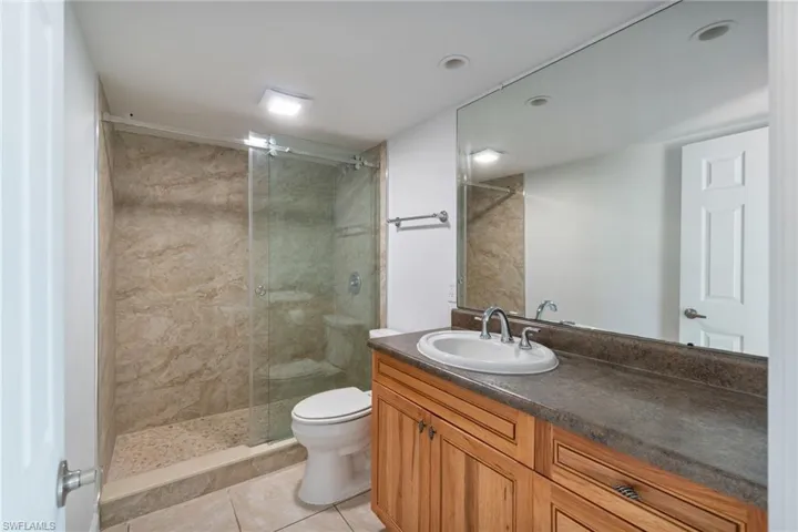 Bathroom with vanity, a stall shower, and light tile patterned floors