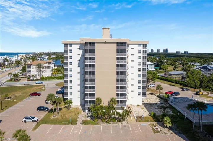View of apartment building / complex with a water view and uncovered parking