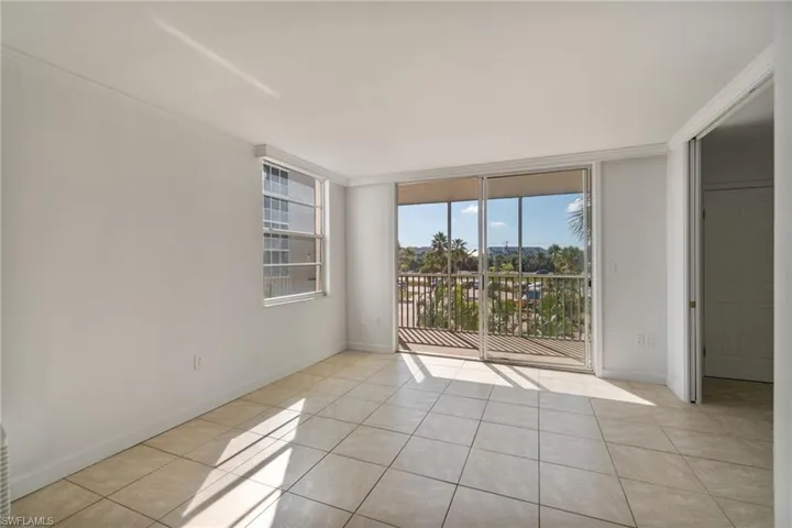 Unfurnished room featuring expansive windows, ornamental molding, and light tile patterned floors