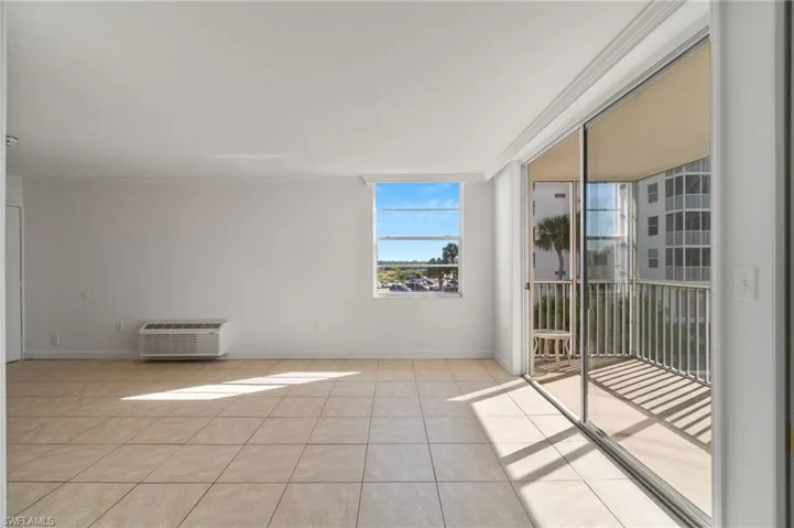 Unfurnished room featuring ornamental molding, a wall mounted air conditioner, and light tile patterned floors
