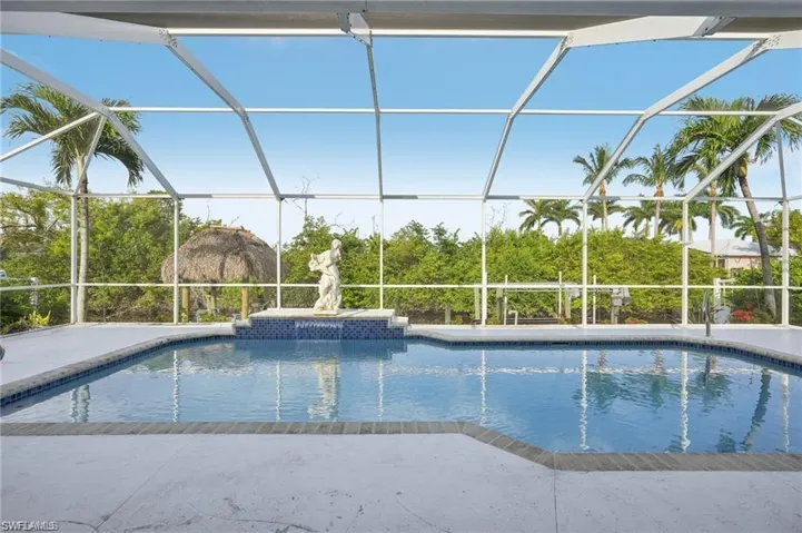 Pool featuring glass enclosure and a patio area