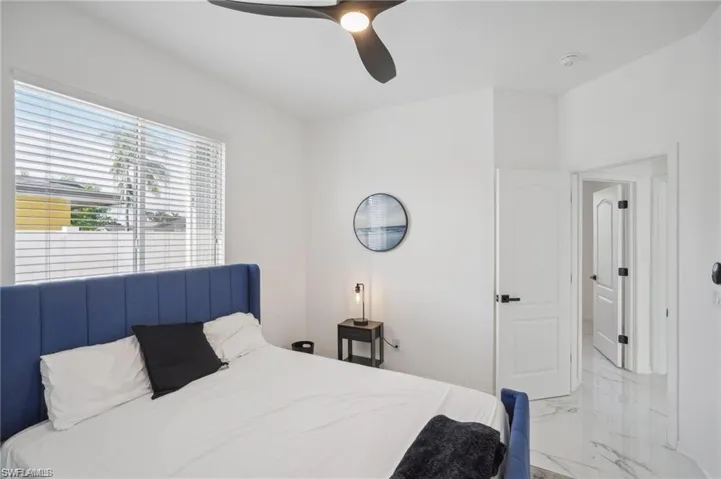 Bedroom with marble finish floor and ceiling fan