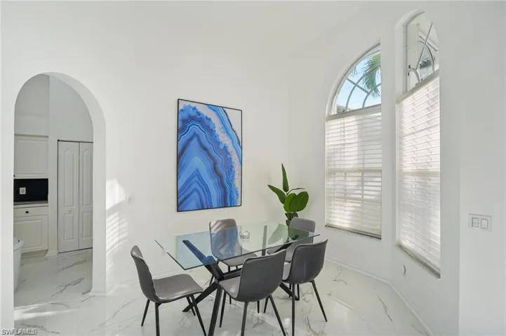 Dining area featuring marble finish floor, baseboards, and arched walkways