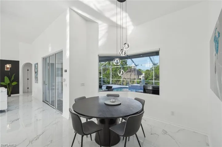 Dining room featuring marble finish floor, baseboards, and arched walkways