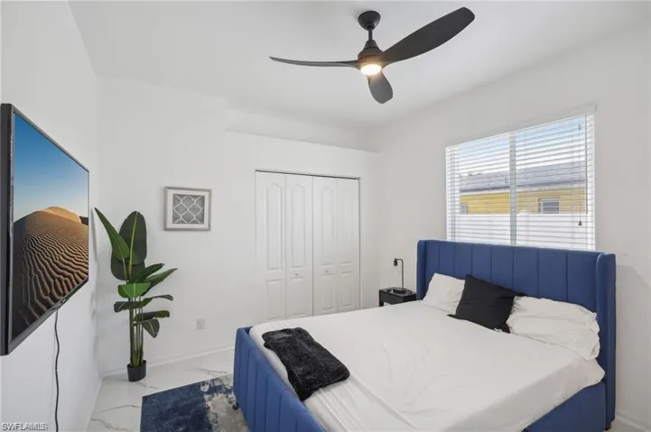 Bedroom with marble finish floor, a closet, and ceiling fan