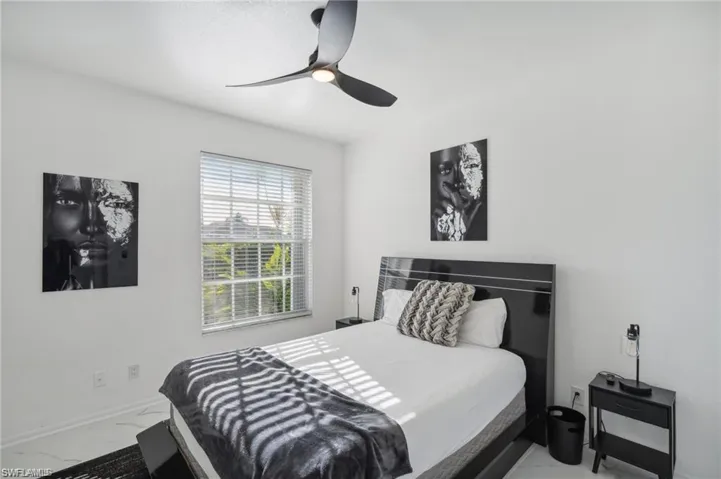 Bedroom featuring marble finish floor, baseboards, and ceiling fan
