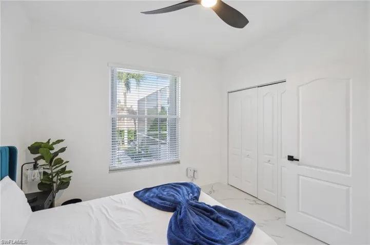 Bedroom featuring marble finish floor, a closet, and ceiling fan