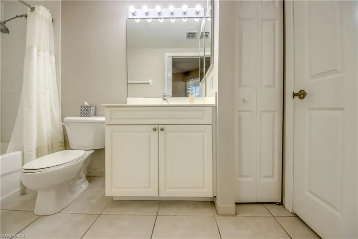 Full bathroom with toilet, shower / tub combo, vanity, and tile patterned floors