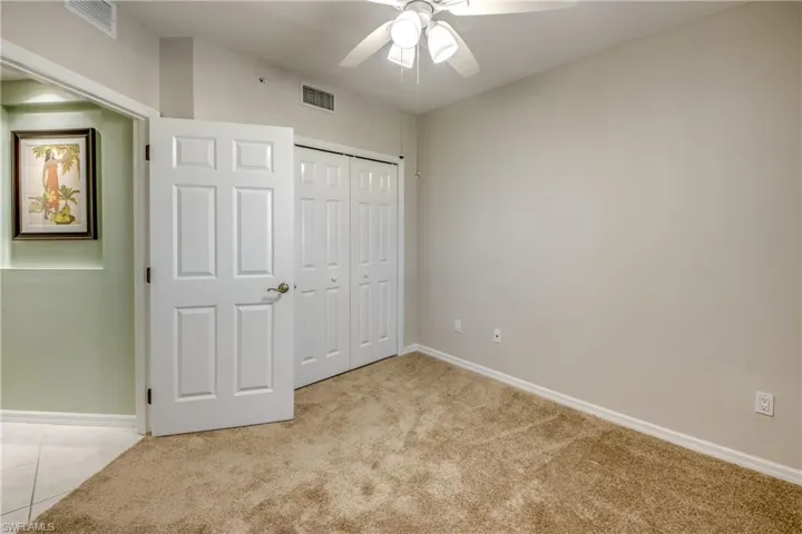 Unfurnished bedroom featuring a closet, ceiling fan, and light colored carpet