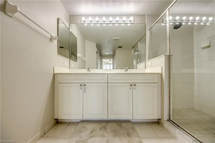 Bathroom with tile patterned floors, vanity, and a shower with shower door