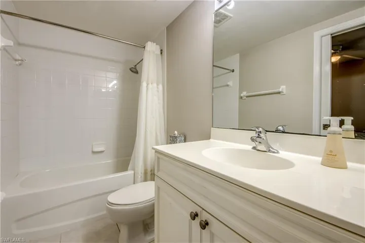 Full bathroom with shower / bath combo with shower curtain, vanity, and toilet