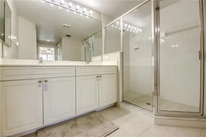 Bathroom featuring vanity, tile patterned floors, and an enclosed shower