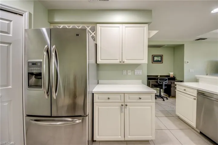 Kitchen featuring white cabinetry, light tile patterned floors, and appliances with stainless steel finishes