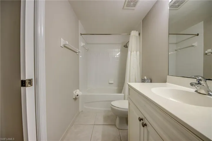 Full bathroom featuring tile patterned flooring, vanity, toilet, and shower / tub combo with curtain