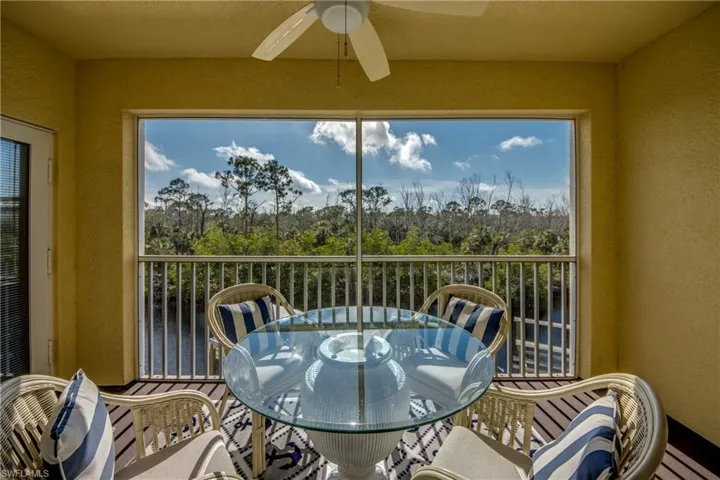 Sunroom featuring ceiling fan and a water view