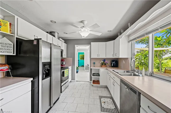 Kitchen featuring white cabinetry, ceiling fan, appliances with stainless steel finishes, and sink
