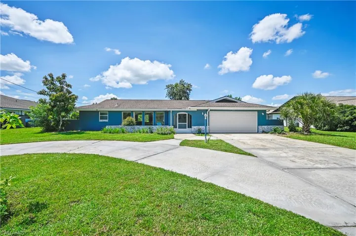Single story home with a garage and a front yard