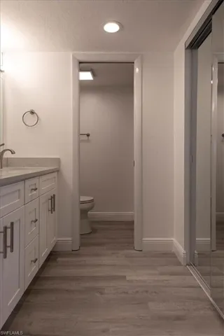 Bathroom featuring hardwood / wood-style floors, vanity, and toilet