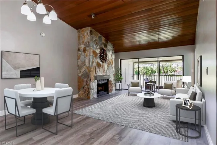 Living room featuring wood ceiling, a notable chandelier, a fireplace, high vaulted ceiling, and light hardwood / wood-style flooring