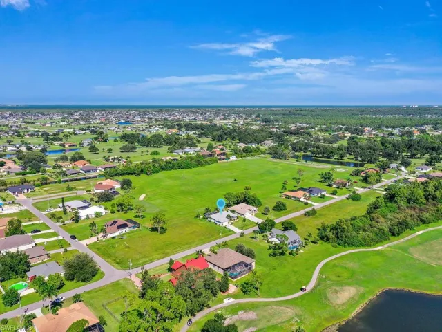 Aerial perspective of suburban area with a golf course and a large body of water