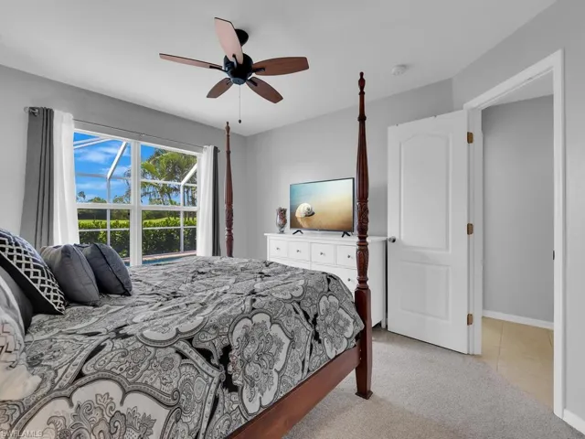 Bedroom with light carpet and a ceiling fan