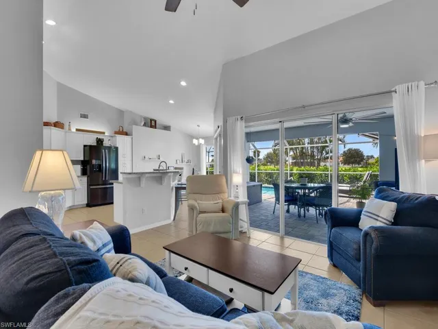 Living room featuring a ceiling fan, light tile patterned floors, recessed lighting, high vaulted ceiling, and a sunroom