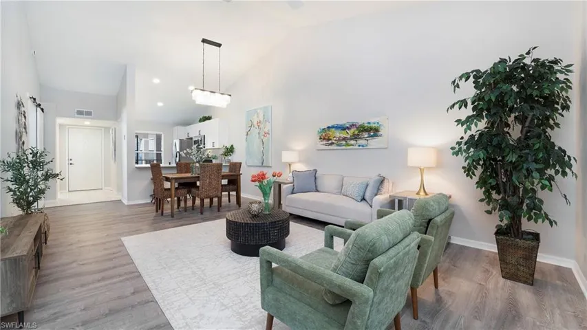 Living area featuring high vaulted ceiling and light wood-type flooring
