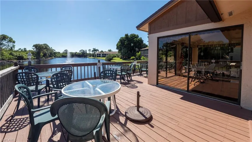 Wooden deck with outdoor dining area and a water view