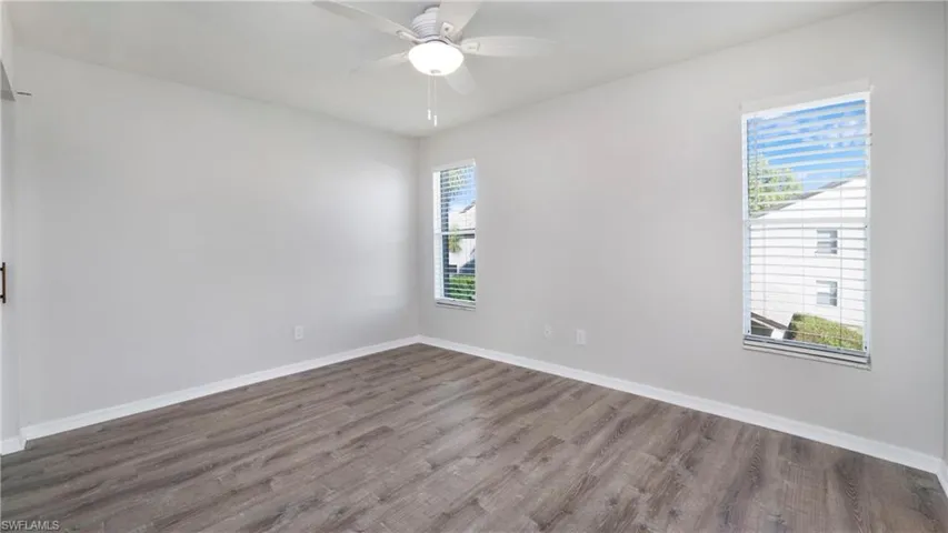 Empty room with wood finished floors and a ceiling fan