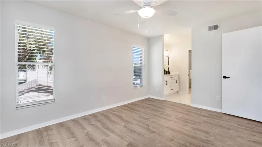 Unfurnished bedroom with light wood finished floors, ceiling fan, and connected bathroom