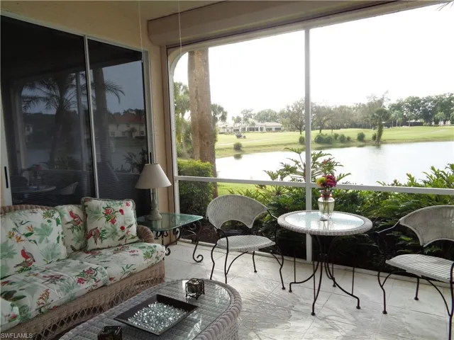 Sunroom / solarium with a water view and marble finish floors