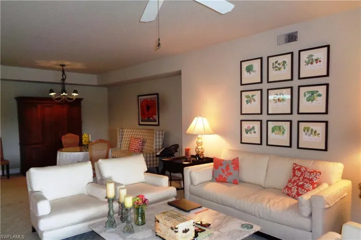 Carpeted living room with a chandelier and a ceiling fan