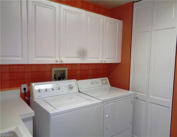 Laundry room with washer and clothes dryer and cabinet space