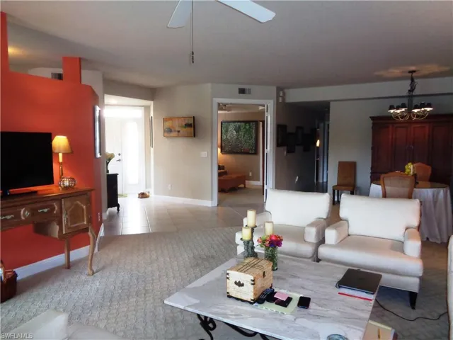 Living room featuring a chandelier, a ceiling fan, and tile patterned floors