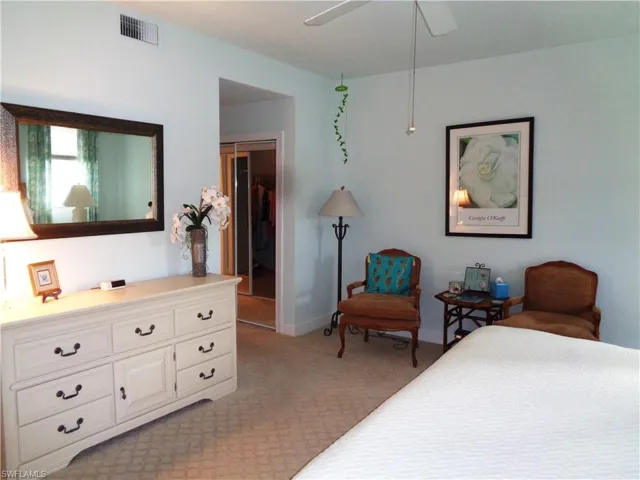 Bedroom with light colored carpet and a ceiling fan