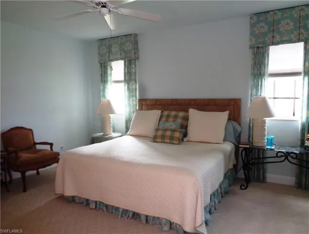 Bedroom featuring multiple windows, carpet flooring, and a ceiling fan