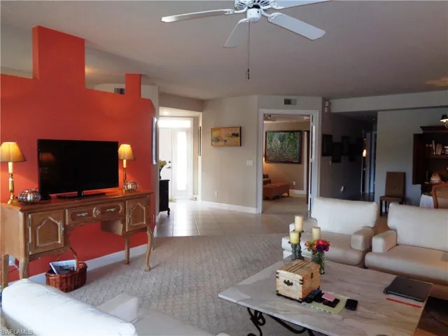 Living room with a ceiling fan and tile patterned floors