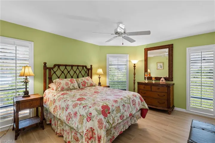 Bedroom with multiple windows, ceiling fan, and light hardwood / wood-style floors