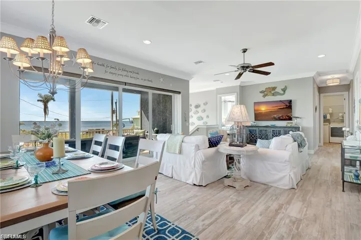 Living area with ornamental molding, light wood-type flooring, a chandelier, and recessed lighting