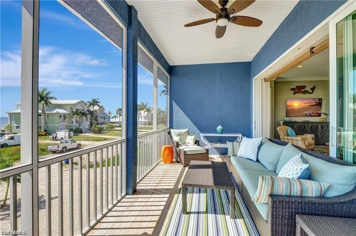 Sunroom featuring ceiling fan, an outdoor hangout area, a balcony, and a residential view