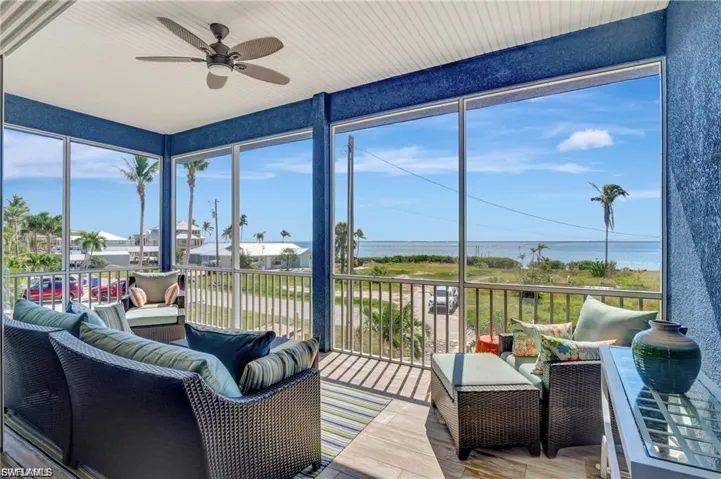 Sunroom featuring a water view and wood finished floors