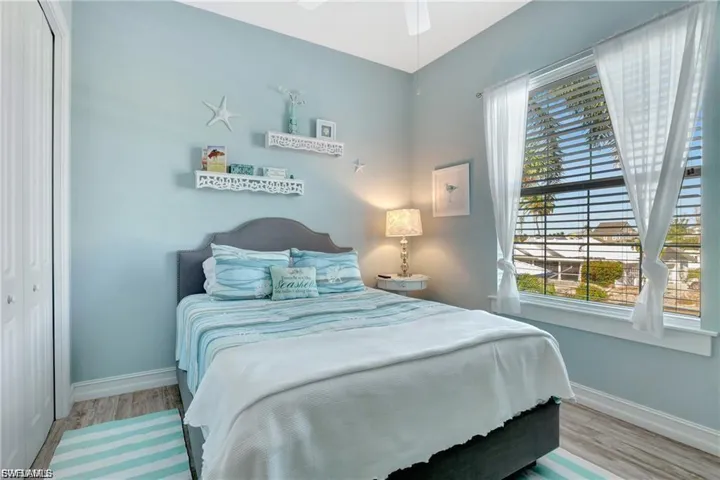 Bedroom featuring a closet, light wood-style floors, and ceiling fan
