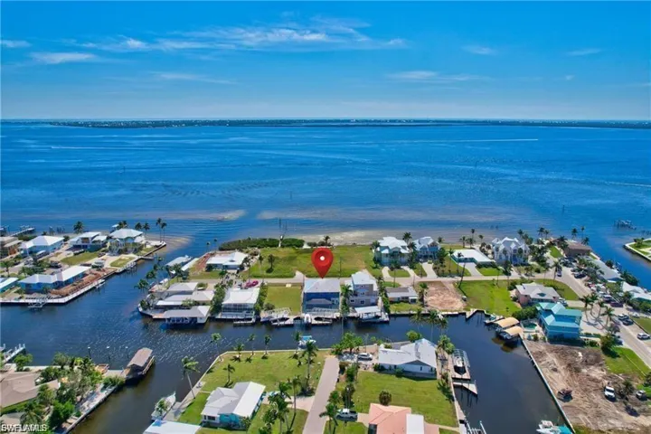 Aerial view of property and surrounding area with a large body of water and nearby suburban area