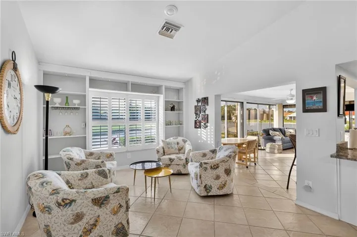 Living area with built in features, healthy amount of natural light, and light tile patterned flooring